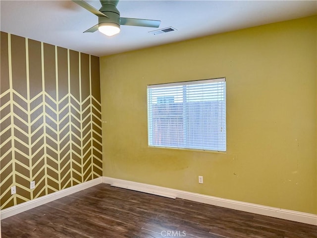 unfurnished room with dark wood finished floors, ceiling fan, and baseboards