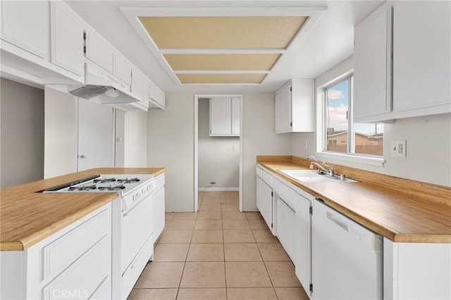 kitchen featuring light tile patterned flooring, white appliances, white cabinetry, and a sink