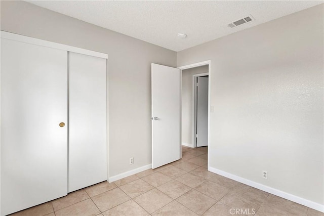 unfurnished bedroom with visible vents, baseboards, and a textured ceiling