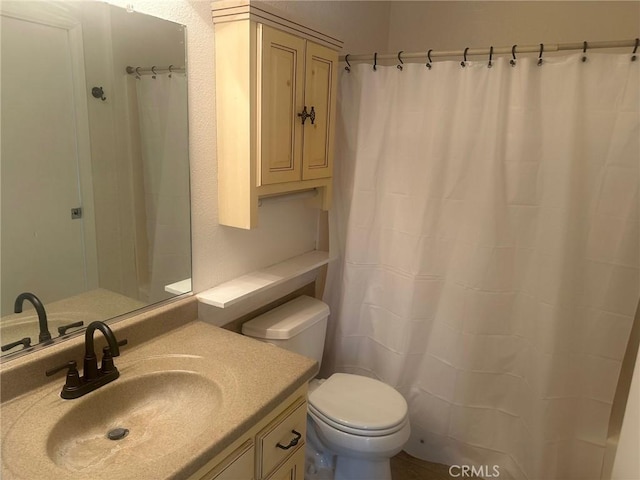 bathroom with a shower with shower curtain, toilet, and vanity