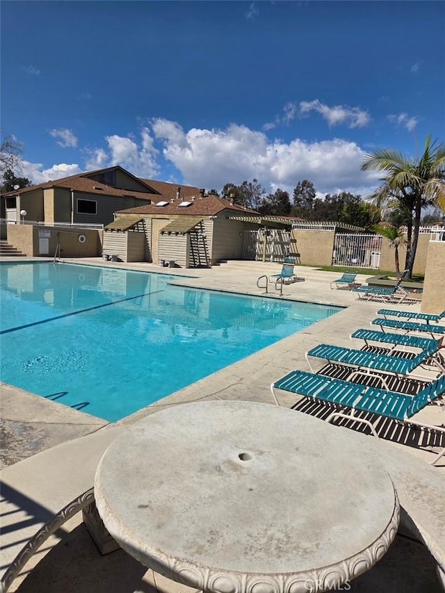 community pool featuring a patio and fence