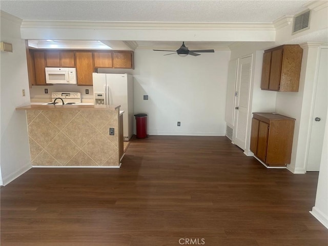 kitchen with white appliances, visible vents, dark wood-style flooring, ceiling fan, and brown cabinets