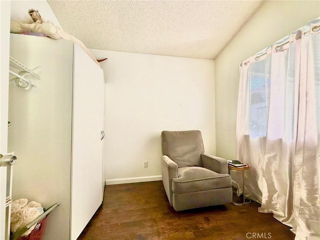 sitting room featuring baseboards, a textured ceiling, and wood finished floors