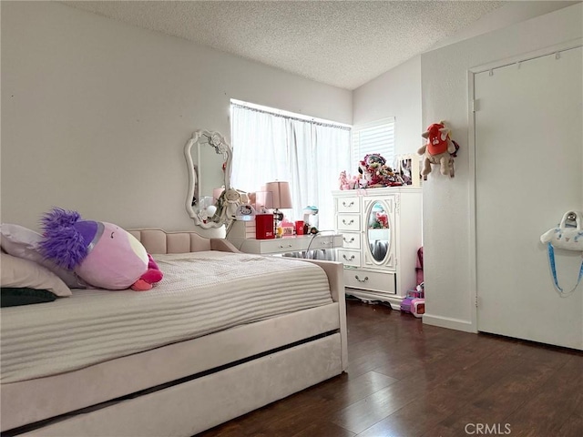 bedroom featuring a textured ceiling and dark wood finished floors