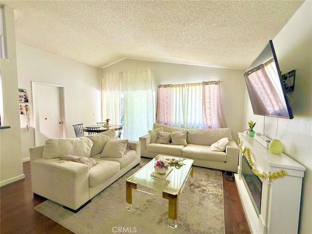 living room featuring baseboards, a textured ceiling, wood finished floors, and vaulted ceiling