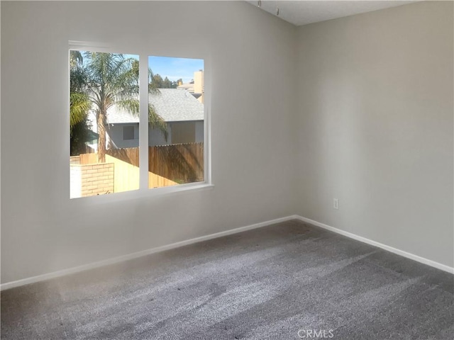 unfurnished room featuring baseboards and carpet floors