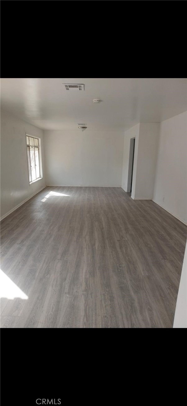 empty room featuring visible vents and wood finished floors