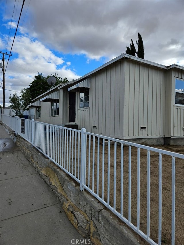 view of side of home with board and batten siding and fence private yard