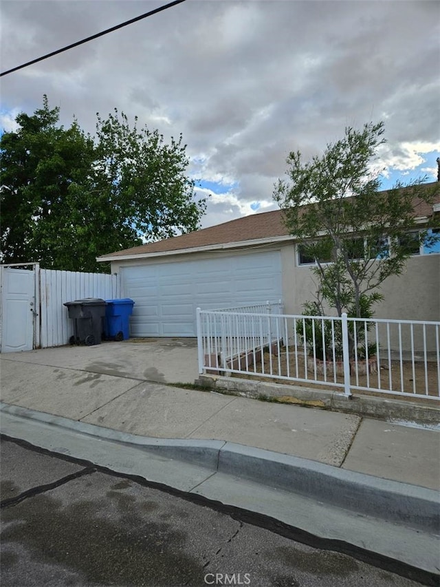 view of side of home with driveway and fence private yard