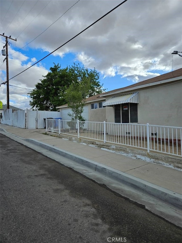 view of front of house with stucco siding, a gate, and a fenced front yard