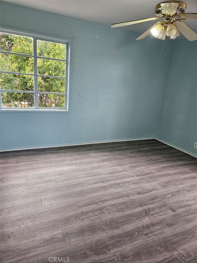 spare room featuring ceiling fan, wood finished floors, and baseboards