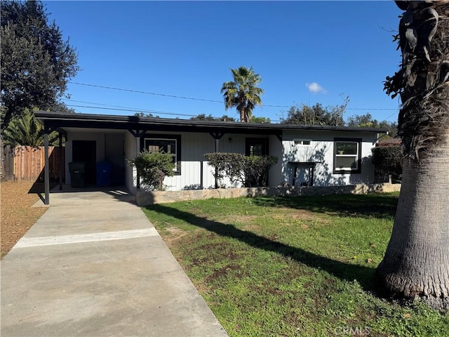 view of front of property with a carport, a front lawn, driveway, and fence