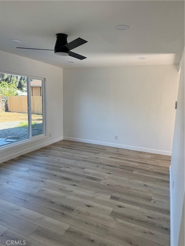 unfurnished room with wood finished floors, baseboards, and ceiling fan