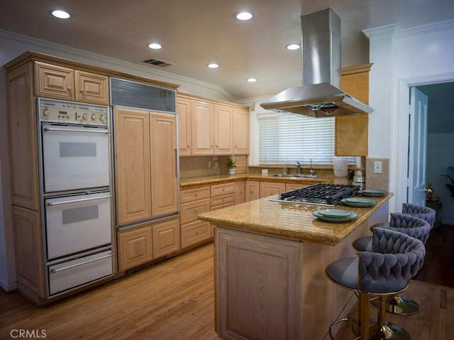 kitchen featuring stainless steel gas cooktop, double oven, a peninsula, island exhaust hood, and a warming drawer