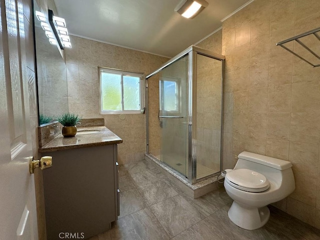 full bathroom featuring toilet, vanity, ornamental molding, a stall shower, and tile walls