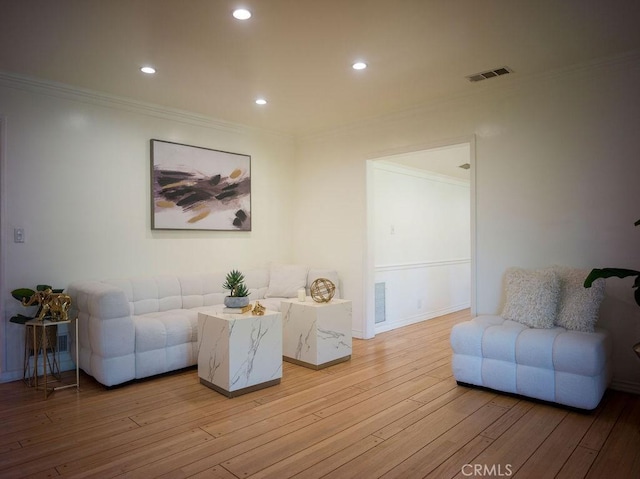 living room featuring visible vents, light wood-style flooring, ornamental molding, recessed lighting, and baseboards