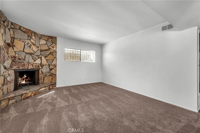 unfurnished living room with visible vents, carpet, and a stone fireplace