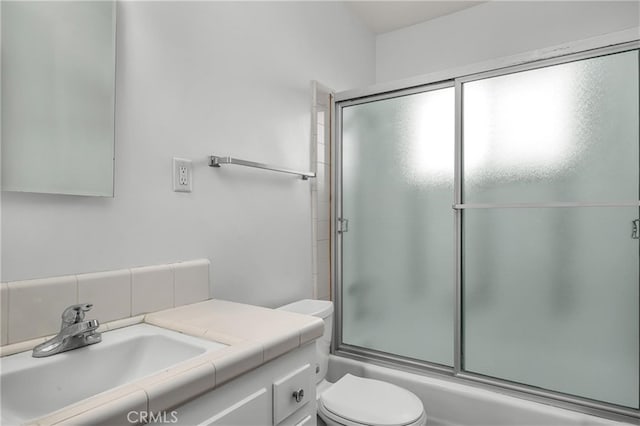 bathroom with enclosed tub / shower combo, toilet, and vanity