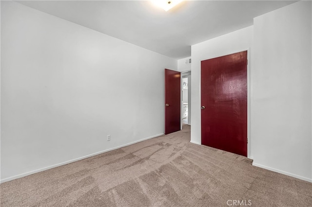 unfurnished bedroom featuring carpet flooring, visible vents, and baseboards