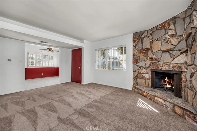 unfurnished living room with carpet flooring, a healthy amount of sunlight, a fireplace, and visible vents