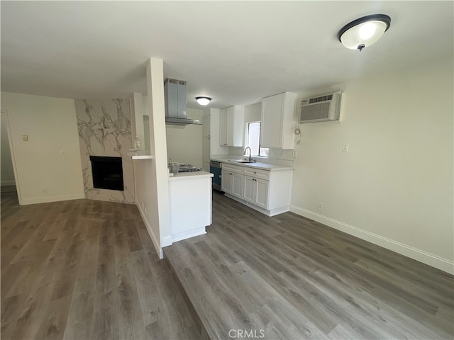 kitchen featuring open floor plan, light countertops, appliances with stainless steel finishes, a wall mounted AC, and a sink