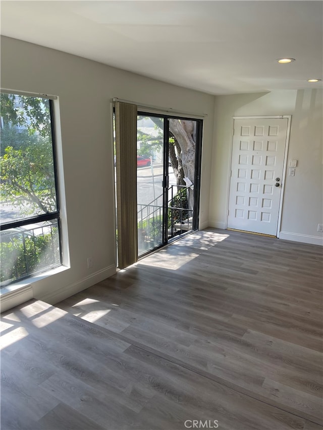 spare room featuring baseboards and wood finished floors