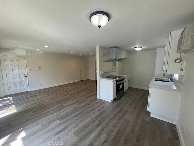 kitchen with stainless steel range with gas cooktop, extractor fan, light countertops, white cabinets, and a sink