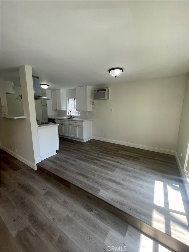 kitchen featuring white cabinets, light countertops, and baseboards