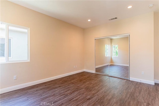 unfurnished room with visible vents, recessed lighting, dark wood-type flooring, and baseboards