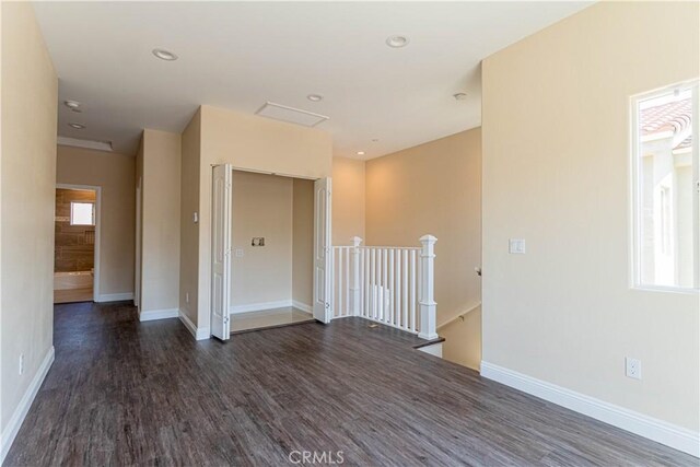 unfurnished room with plenty of natural light, wood finished floors, and baseboards