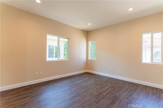 unfurnished room featuring a wealth of natural light, dark wood-style floors, recessed lighting, and baseboards