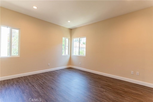 unfurnished room featuring dark wood-type flooring, recessed lighting, and baseboards