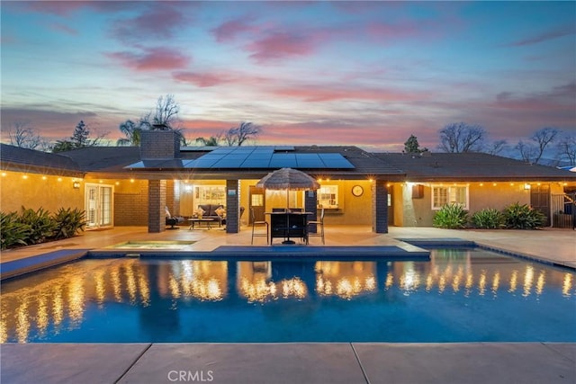 pool with outdoor dining area and a patio area