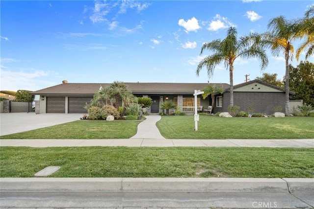 ranch-style house featuring an attached garage, concrete driveway, and a front yard