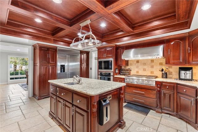 kitchen with tasteful backsplash, built in appliances, stone tile flooring, coffered ceiling, and wall chimney exhaust hood