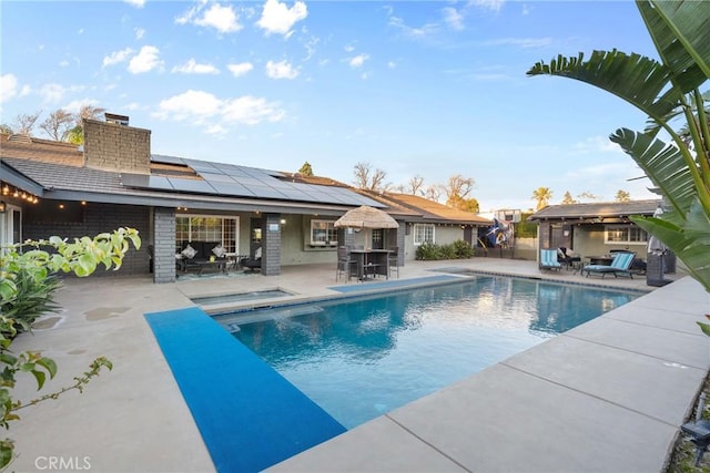 pool with outdoor dining area and a patio