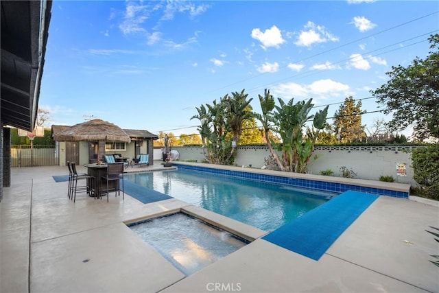 view of pool with a fenced backyard, a gazebo, a fenced in pool, an in ground hot tub, and a patio area