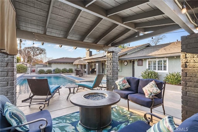 view of patio with a fenced in pool, an outdoor living space with a fire pit, and fence