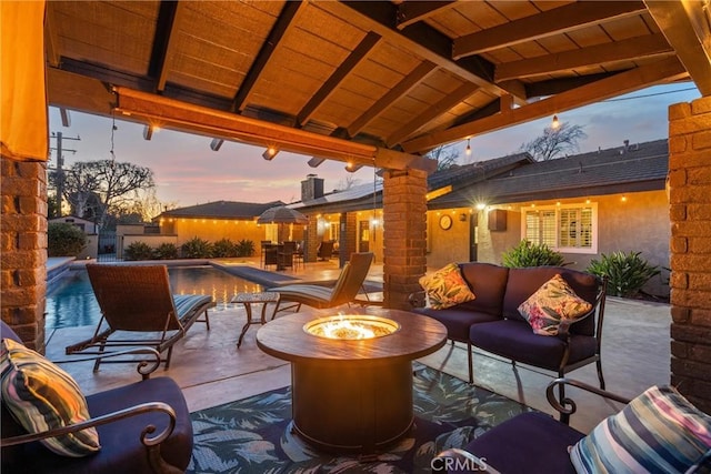 view of patio with an outdoor pool and an outdoor living space with a fire pit