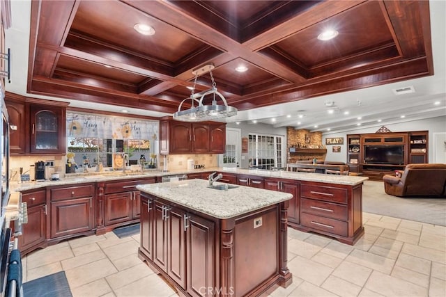 kitchen featuring visible vents, an island with sink, coffered ceiling, open floor plan, and dark brown cabinets