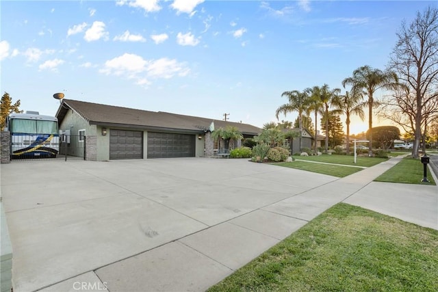 view of front of property featuring a yard, a garage, concrete driveway, and fence