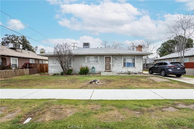 view of front of property with a front lawn, central AC unit, fence, and a chimney