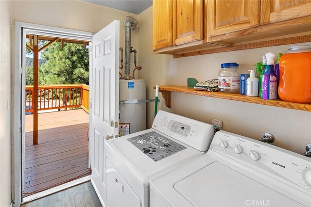 laundry room with secured water heater, wood finished floors, cabinet space, and washing machine and clothes dryer