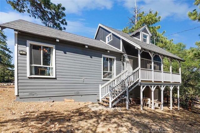 back of house featuring faux log siding, stairway, and crawl space