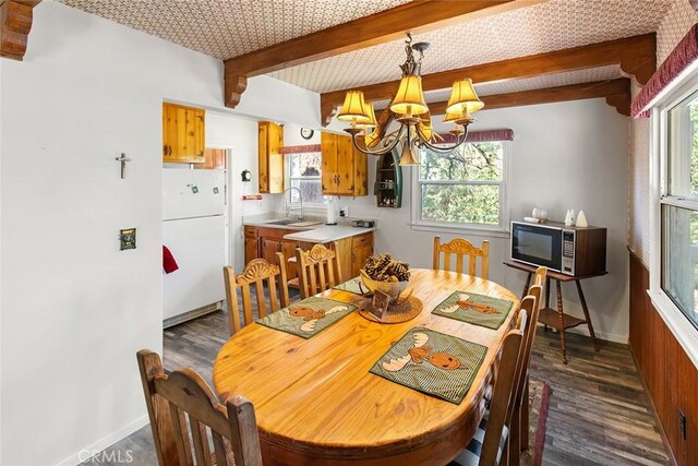 dining area featuring beamed ceiling, baseboards, dark wood-style flooring, and a chandelier