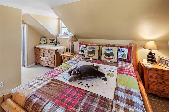 carpeted bedroom with baseboards and vaulted ceiling