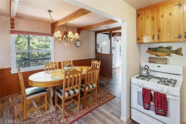 dining space with wallpapered walls, light wood-style floors, a chandelier, and wainscoting