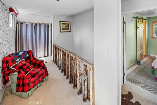 interior space with a barn door, carpet flooring, and baseboards