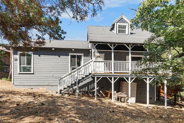 rear view of house with a wooden deck and stairs