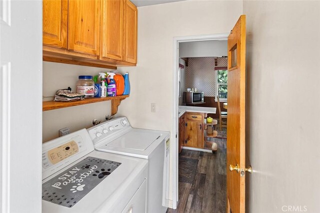 laundry room with dark wood finished floors, cabinet space, and washing machine and dryer